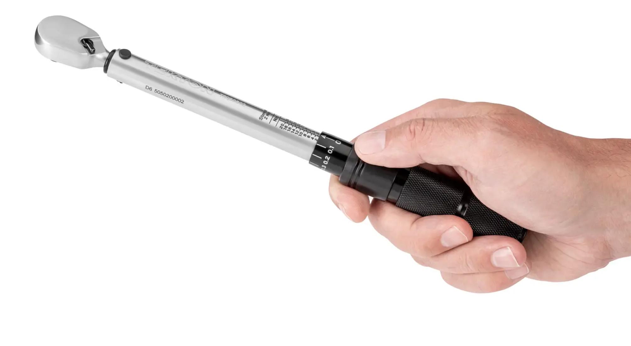 A person holding a Tekton 1/4 inch micrometer torque wrench