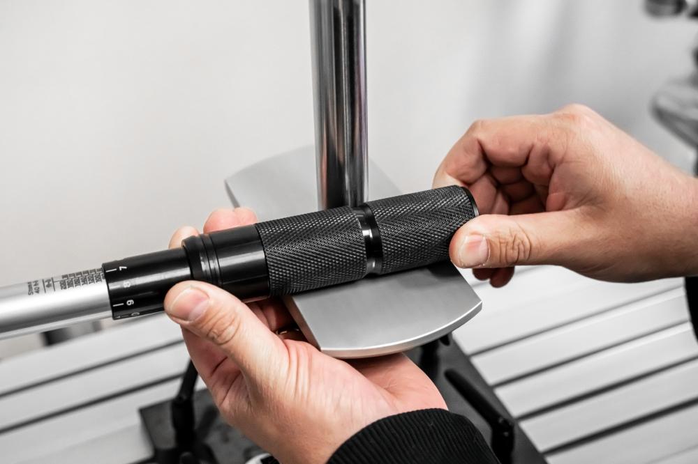 A person testing the calibration of a Tekton torque wrenches