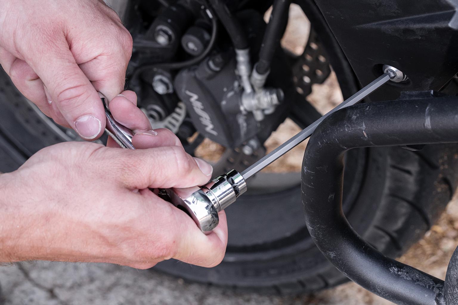 A ball end bit socket being used with a ratchet to access an obstructed fastener.