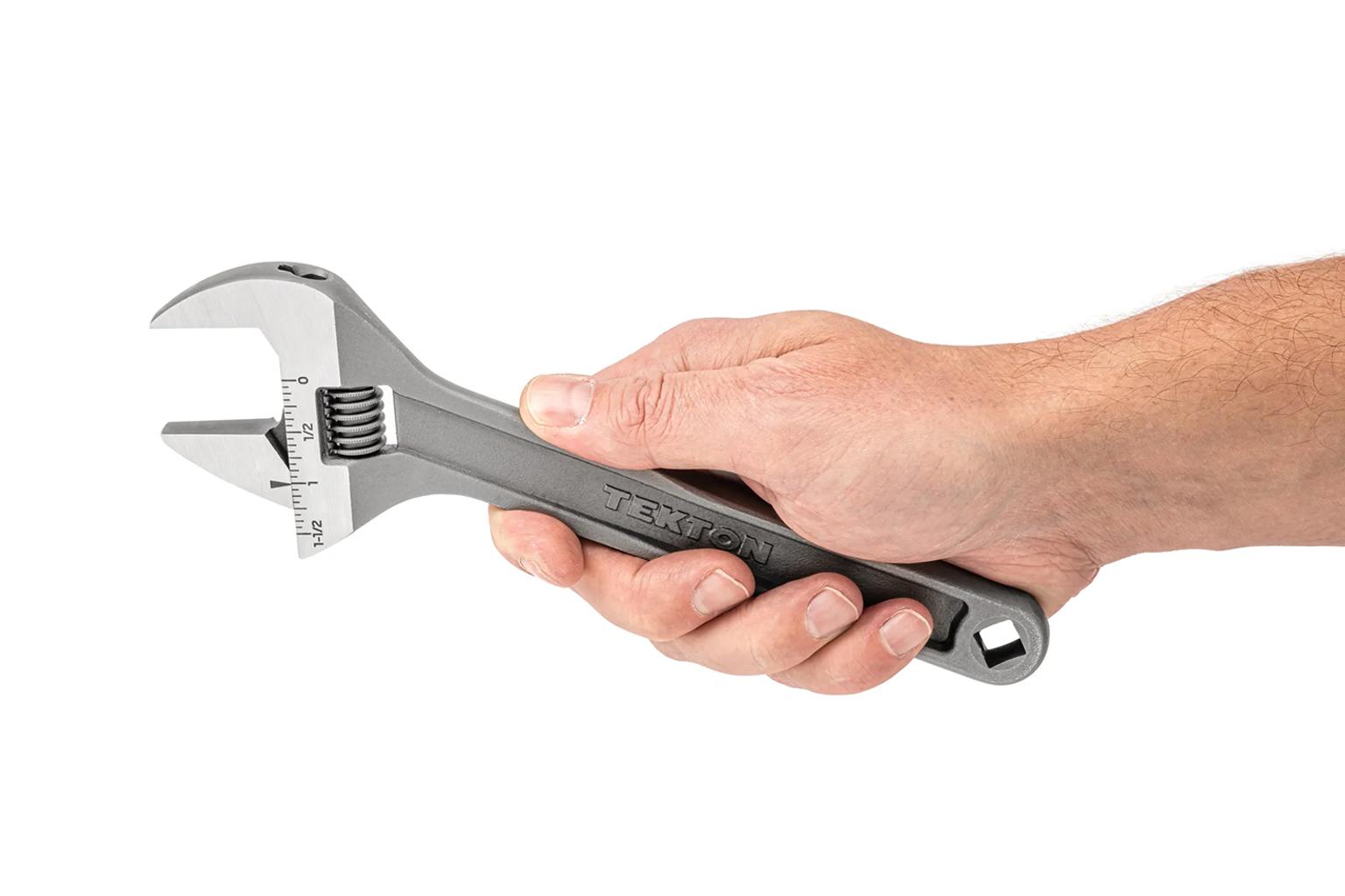 A Tekton 9 Inch Adjustable Wrench being held by the handle.