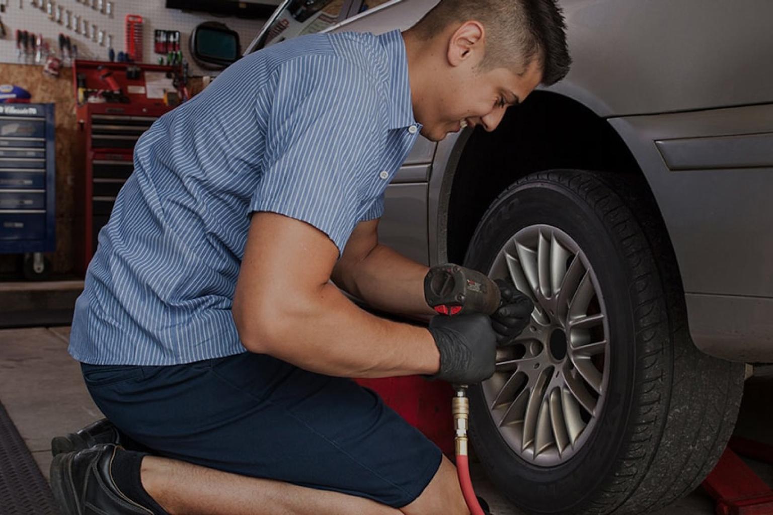 Student mechanic working on a tire